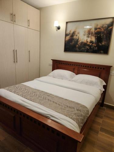a large bed in a bedroom with a painting on the wall at 1 bedroom at Alessa Executive Apartments 1103 in Nairobi