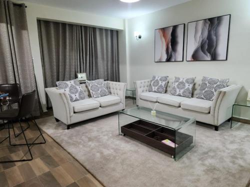 a living room with two couches and a coffee table at 1 bedroom at Alessa Executive Apartments 1103 in Nairobi