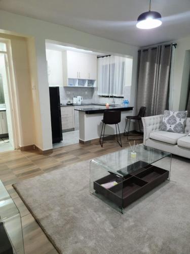 a living room with a couch and a glass table at 1 bedroom at Alessa Executive Apartments 1103 in Nairobi