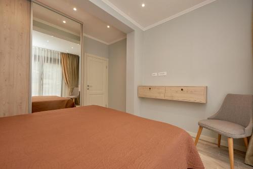 a bedroom with a bed and a chair and a mirror at Sunbreeze Delux Vilas in Budva