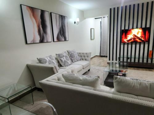 a living room with two couches and a fireplace at 1 bedroom at Alessa Executive Apartments 1103 in Nairobi