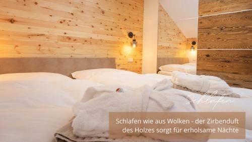 een hotelkamer met 2 bedden met witte lakens bij Zirben -Chalet 2 in Winkl Heiligenblut