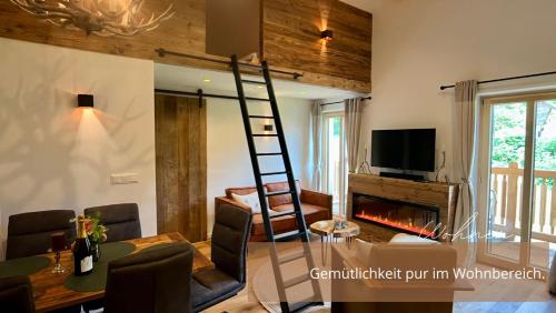 a living room with a ladder and a fireplace at Zirben -Chalet 2 in Winkl Heiligenblut