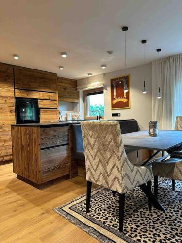 a kitchen with a table and chairs in a room at Spa, Sport & City Luxury Ski-in Ski-Out Apartment in Kitzbühel
