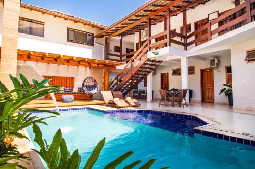 a villa with a swimming pool and a house at Hotel Bem Brasil in Porto Seguro