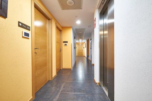 a hallway of a hospital with yellow walls and a long hallway sidx sidx at Hotel Real de Illescas in Illescas