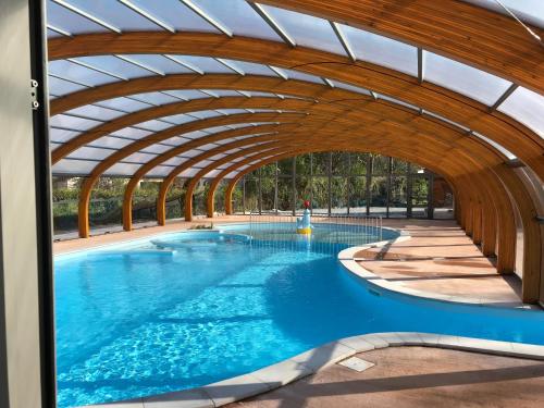 une grande piscine avec une arche dans l'établissement camping les pêcheurs, à Pont-de-Poitte