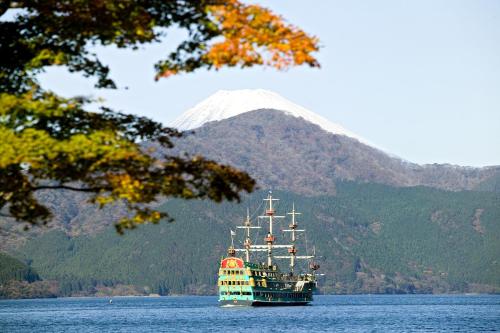 a ship in the water with a mountain in the background at Hakone Hotel in Hakone