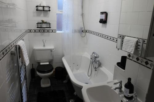 a bathroom with a toilet and a sink and a tub at Relax & Unwind In A Stunning 3BD Home in Sheffield in Sheffield