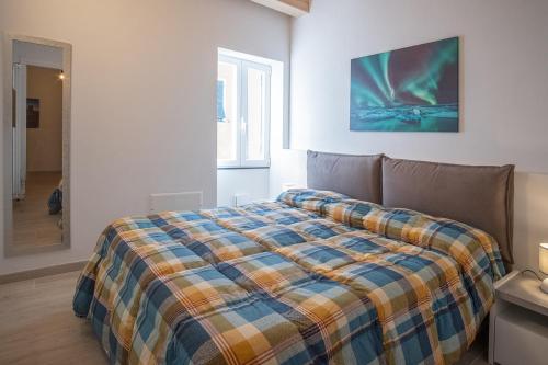 a bedroom with a bed with a plaid blanket on it at HouseImperia in Imperia