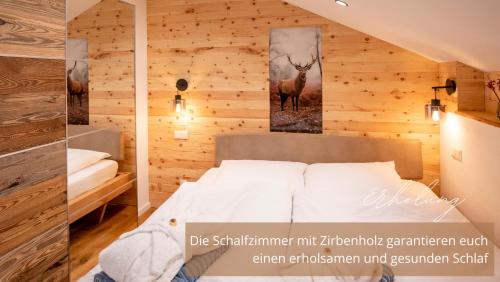 a room with a bed and a picture of a deer at Zirben -Chalet 1 in Winkl Heiligenblut