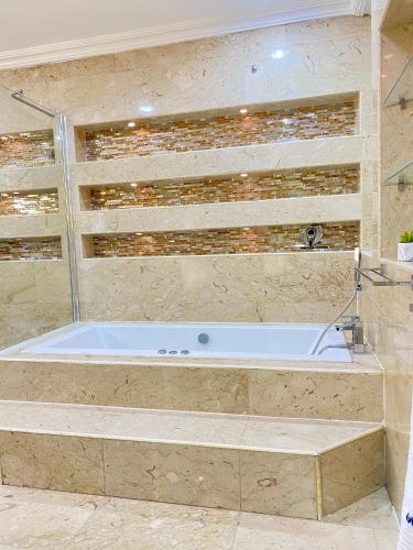 a large bath tub in a bathroom with at Glovis Luxury Suites in Abuja