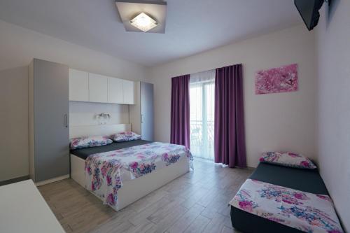 1 Schlafzimmer mit 2 Betten und einem Fenster in der Unterkunft Apartman M&S s bazenom in Podstrana