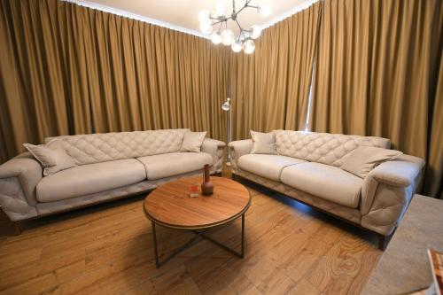 a living room with two couches and a table at Vila Ana in Kalesija