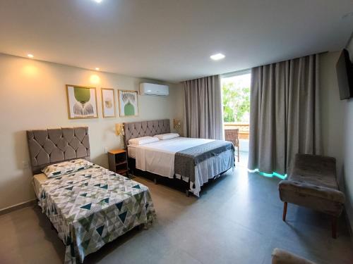 a hotel room with two beds and a window at Flats Marina Maragogi in Maragogi