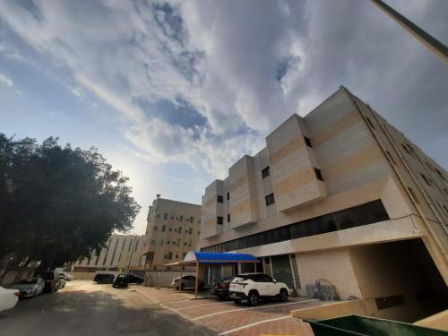 um edifício com carros estacionados num parque de estacionamento em الساعه 60 الفندقيه em Dammam