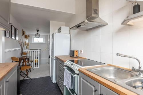 cocina con fregadero y nevera en Large two bedroom Apartment in Cliftonville, en Kent