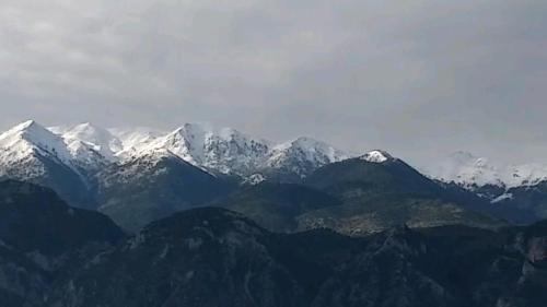 a mountain range with snow capped mountains in the distance at HELLAS PALACE ROOMS balcony in Sparti