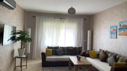 een woonkamer met een bank en een raam bij Apartement Marina Zina, Agadir in Agadir