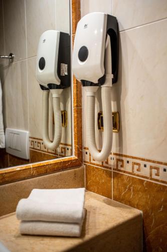 a bathroom with two hair dryers and a mirror at Hotel Mary in Vicenza