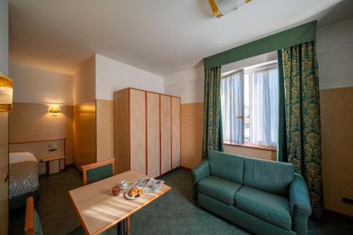 ヴィチェンツァにあるHotel Maryの青い椅子、テーブル、窓が備わる客室です。