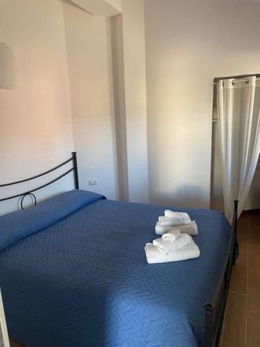 a bedroom with a blue bed with towels on it at case al borgo in Porto Pollo