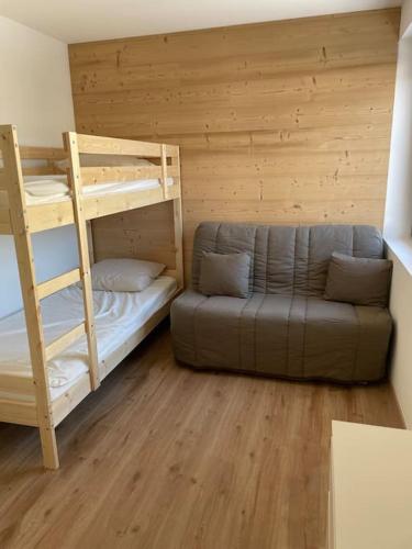 une chambre avec deux lits superposés et un canapé dans l'établissement Chalet Saint Victor, Praz sur Arly, à Praz-sur-Arly