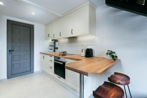 a kitchen with white cabinets and a wooden counter top at YANNIS RETREAT in Lefkada Town