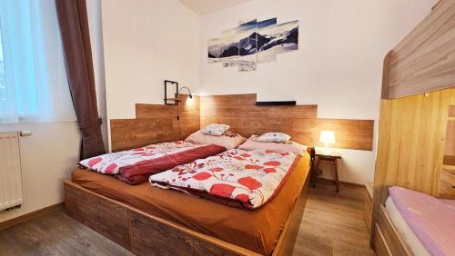 Schlafzimmer mit einem Bett mit roten und weißen Decken in der Unterkunft Apartmán Pod Žalým - Hořejší Vrchlabí in Vrchlabí