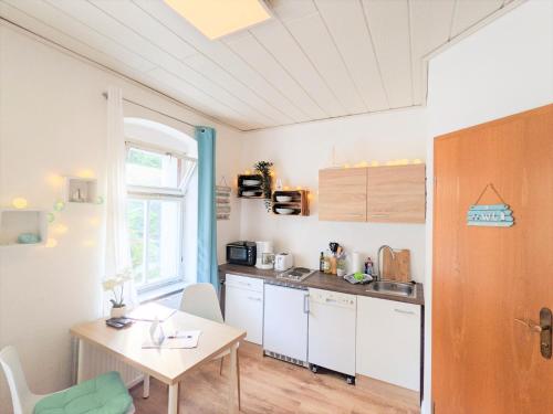 a small kitchen with a table and a table and a table at H1 - Urlaubsmagie - Pool & Terrasse zum Entspannen in Sebnitz