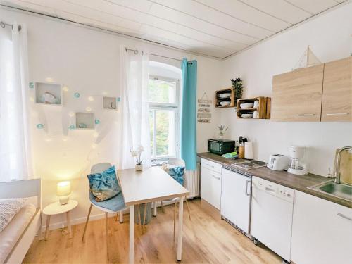 a kitchen with white cabinets and a table and chairs at H1 - Urlaubsmagie - Pool & Terrasse zum Entspannen in Sebnitz
