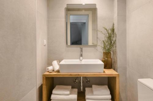 a bathroom with a sink and a mirror and towels at Nirvana - Unalome Villas in Andipáta Erísou