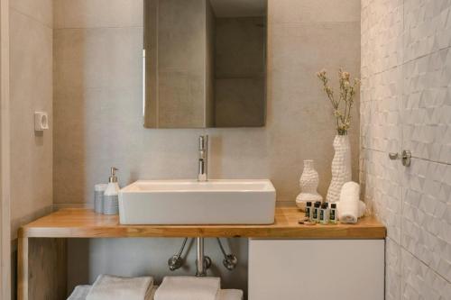 a bathroom with a white sink and a mirror at Nirvana - Unalome Villas in Andipáta Erísou