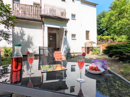 a table with two glasses of wine and a bowl of fruit at H1 - Urlaubsmagie - Pool & Terrasse zum Entspannen in Sebnitz