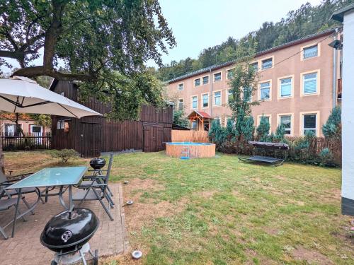 a backyard with a ping pong table and umbrella at H1 - Urlaubsmagie - Pool & Terrasse zum Entspannen in Sebnitz