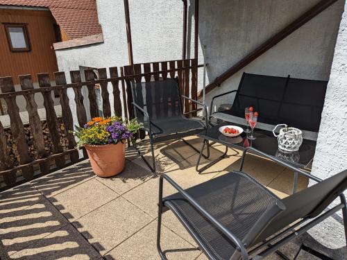 a patio with two chairs and a table with flowers at H1 - Urlaubsmagie - Pool & Terrasse zum Entspannen in Sebnitz