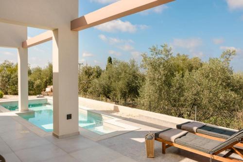 a house with a swimming pool and a patio at Karma - Unalome Villas in Andipáta Erísou