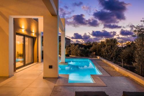 a swimming pool in the backyard of a house at Karma - Unalome Villas in Andipáta Erísou