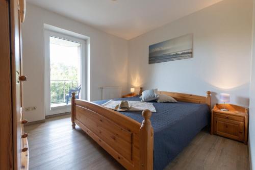 a bedroom with a blue bed and a window at LM7-8 - Ferienwohnung Typ B Komfort in Schottwarden