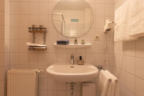 a white bathroom with a sink and a mirror at LM7-8 - Ferienwohnung Typ B Komfort in Schottwarden