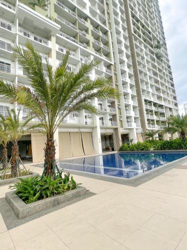 a palm tree in front of a large building at 2BEDROOM Condo for rent in Quezon City in Manila