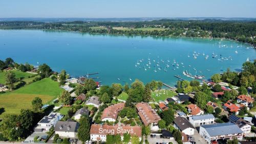 una vista aérea de una ciudad con barcos en el agua en Snug Stays - Design Studio am See mit Terrasse, Garten, Badestelle vor dem Haus, en Wörthsee
