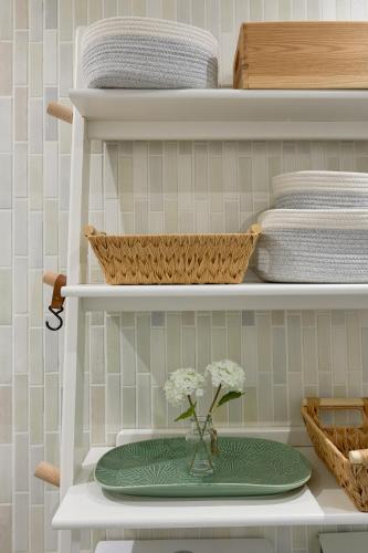 a shelf with a green plate with a vase of flowers at Boujee & chic city centre house in Oxford