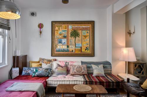 a living room with a couch and a painting on the wall at Boujee & chic city centre house in Oxford