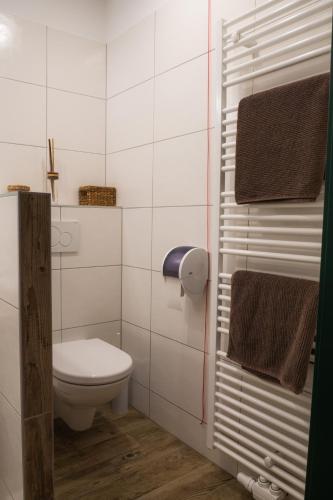 a white bathroom with a toilet and towels at Krumbacherhof in Krumbach Markt