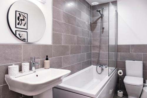 a bathroom with a sink and a tub and a toilet at The Liverpool Escape - Captivating 1BDR Flat in Liverpool