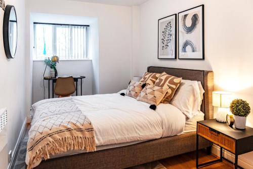 a bedroom with a large bed with white walls at The Liverpool Escape - Captivating 1BDR Flat in Liverpool
