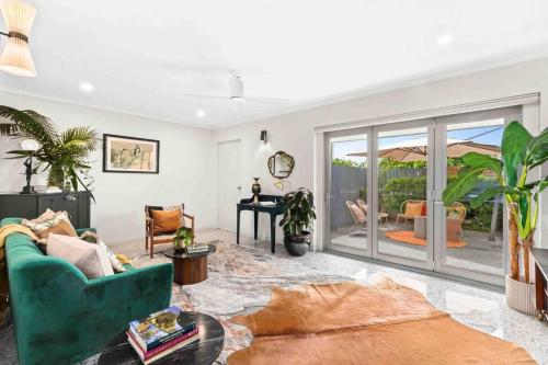 a living room with a green couch and a table at Gatsby Apartment@Mackay 