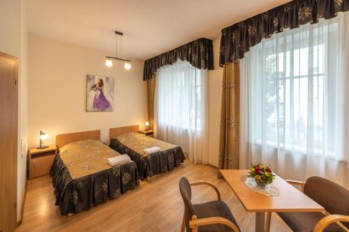 a hotel room with two beds and a table and a dining room at DW Halka in Kudowa-Zdrój