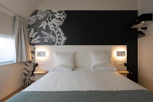 a bedroom with a large white bed with two pillows at Martin's Brugge in Bruges